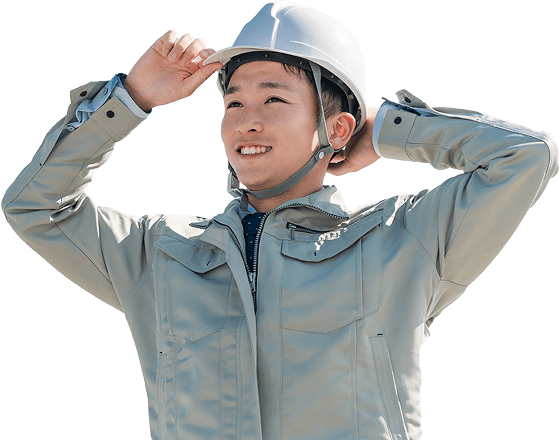 ヘルメットに手をかけて笑顔の作業着の男性